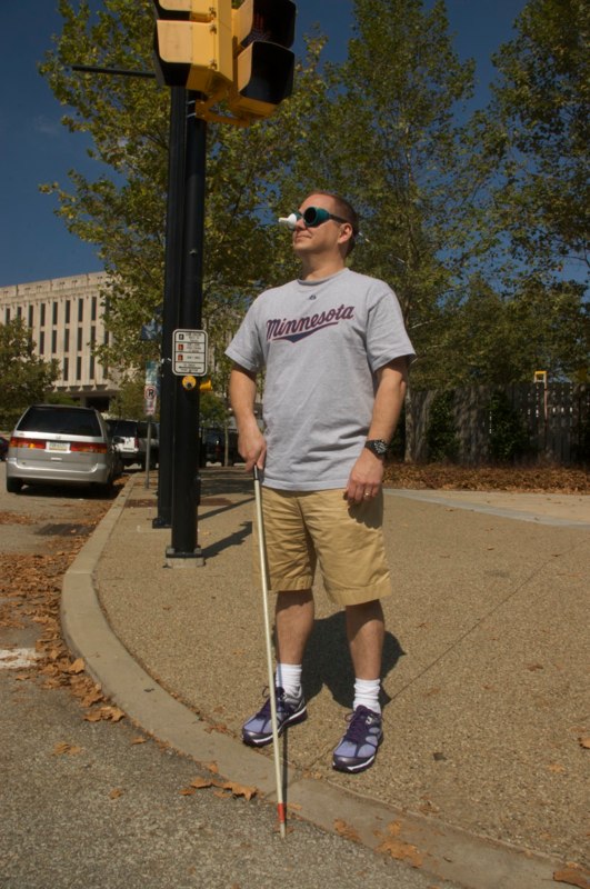Man at crosswalk wearing simulation goggles