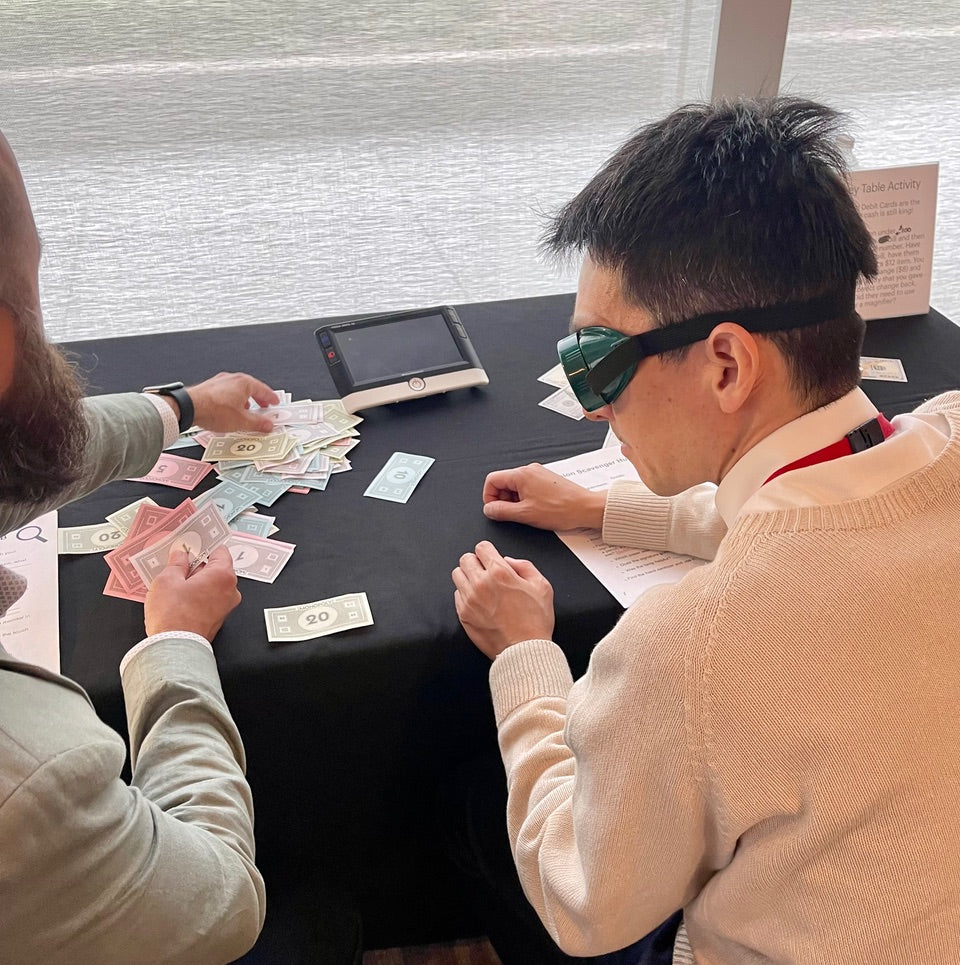 Two people playing a game at a table with simulators on.